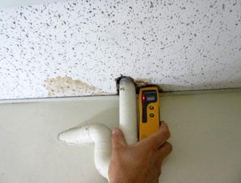 Moisture meter indicates elevated readings to ceiling water stain